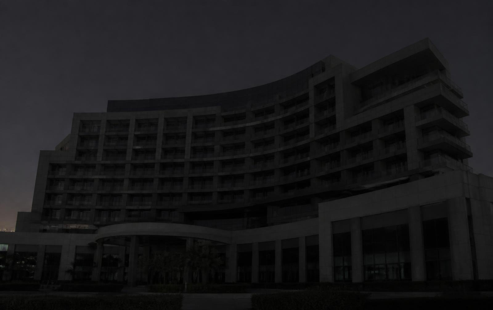 Same building façade at night without architectural lighting